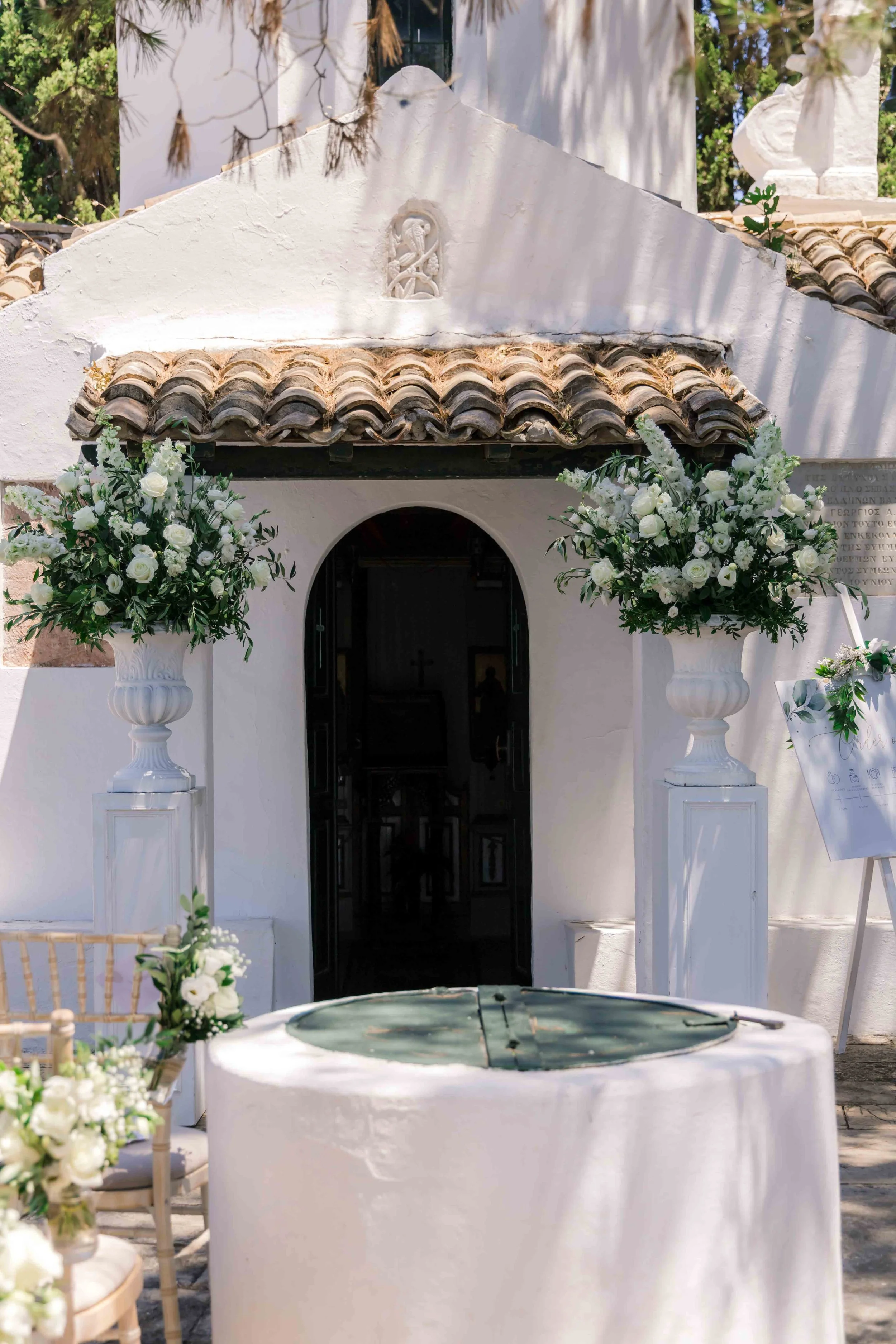 White chapel decorated with two large flower arrangements for a wedding.