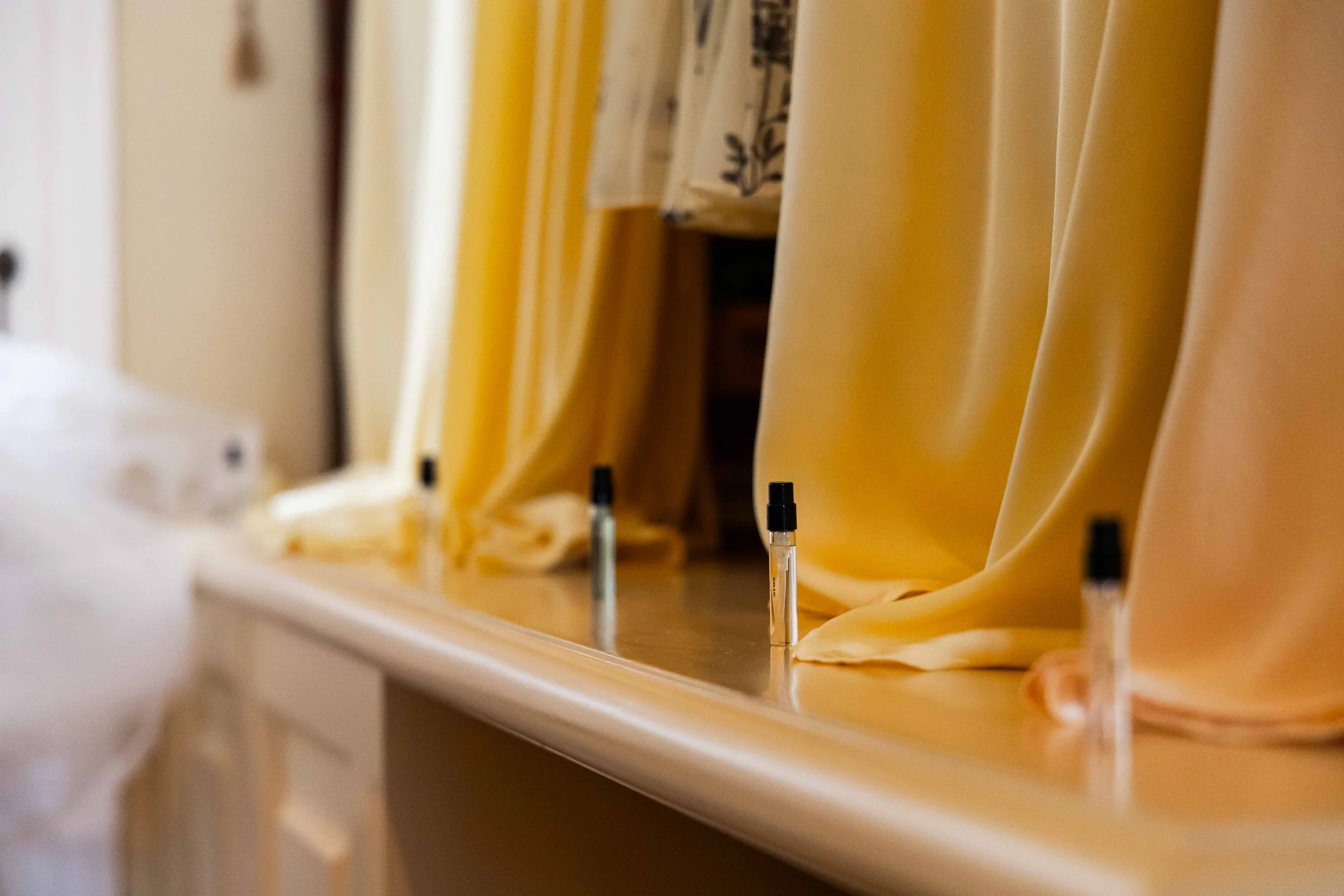 Hospital room with yellow curtains and four IV drip stands.