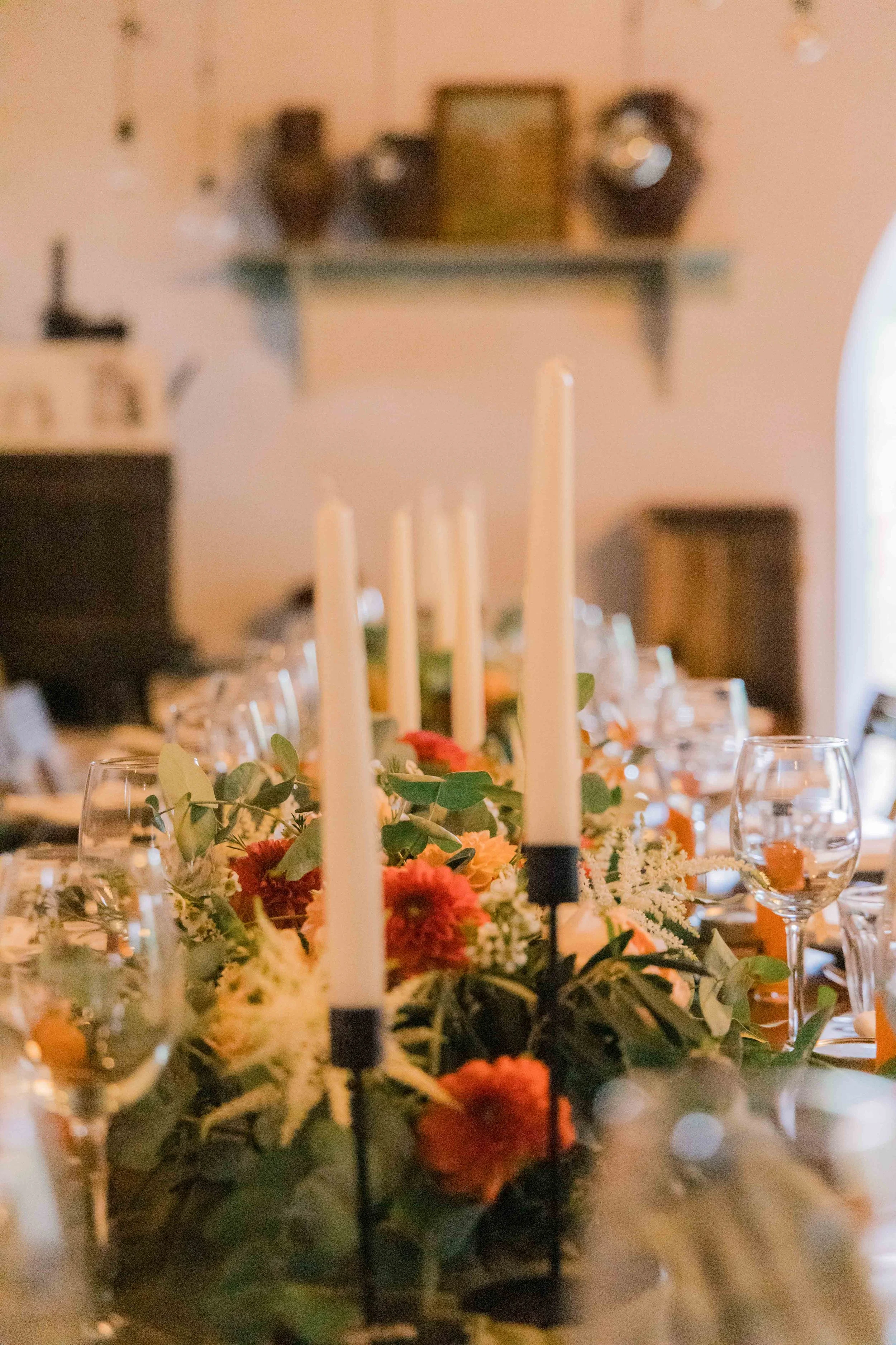 Decorative table setting with candles and flowers for a celebration or event.