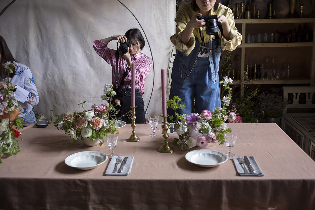 Styling and photographing shapely centrepiece arrangements of spring foliage, ranunculus and apple blossom.