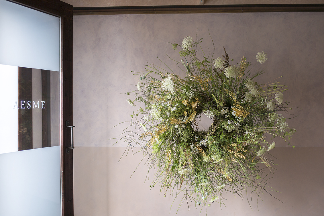Hanging wreath of dried grasses and seedbeds, with ammi and poppy heads