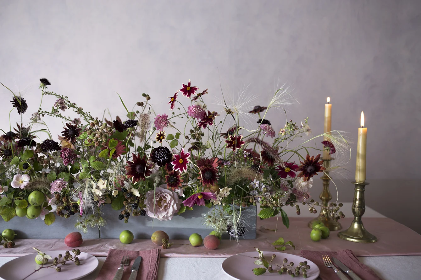 A tablescape of autumnal flowers and grasses made during a private class at Aesme Flower Studio