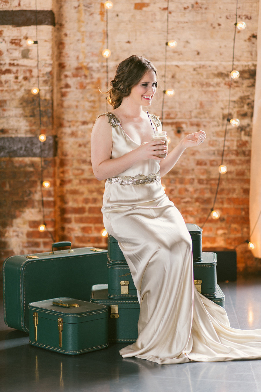 green-vintage-suitcases-string-lights-bride-playful