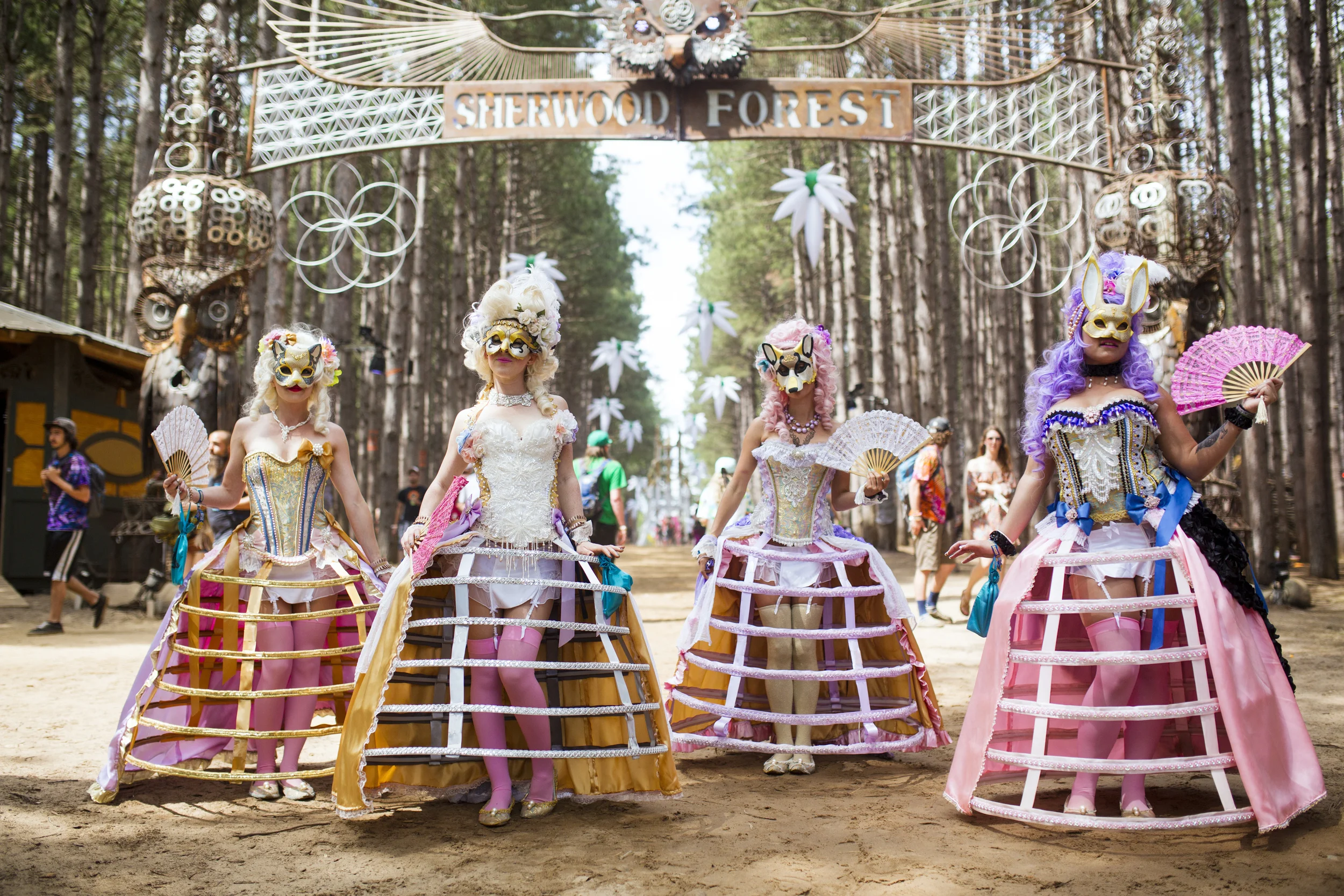 Hired performers dressed in cage dresses and masks greet festival goers as they enter the Sherwood Forest June 27 during the 5th Annual Electric Forest Festival in Rothbury, Mich.