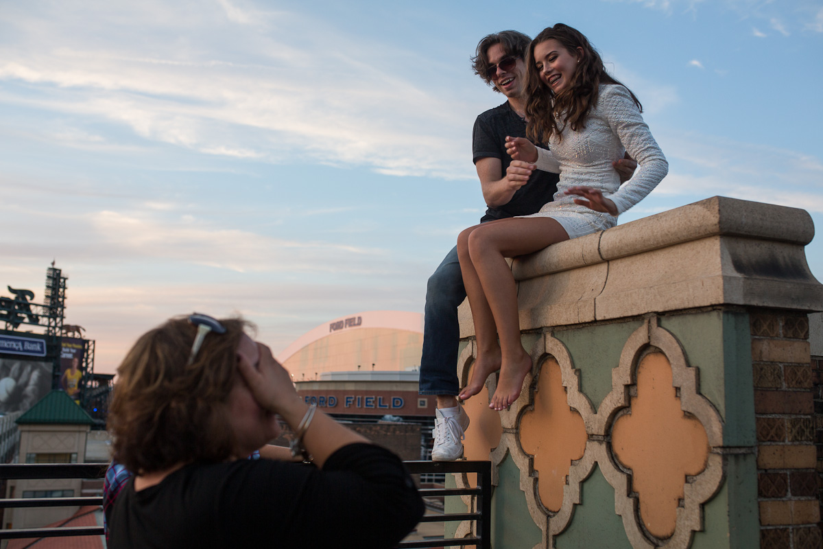 Linda covering her eyes as Bryce pulls Sofia up onto the edge of the wall to get in position for the shot.
