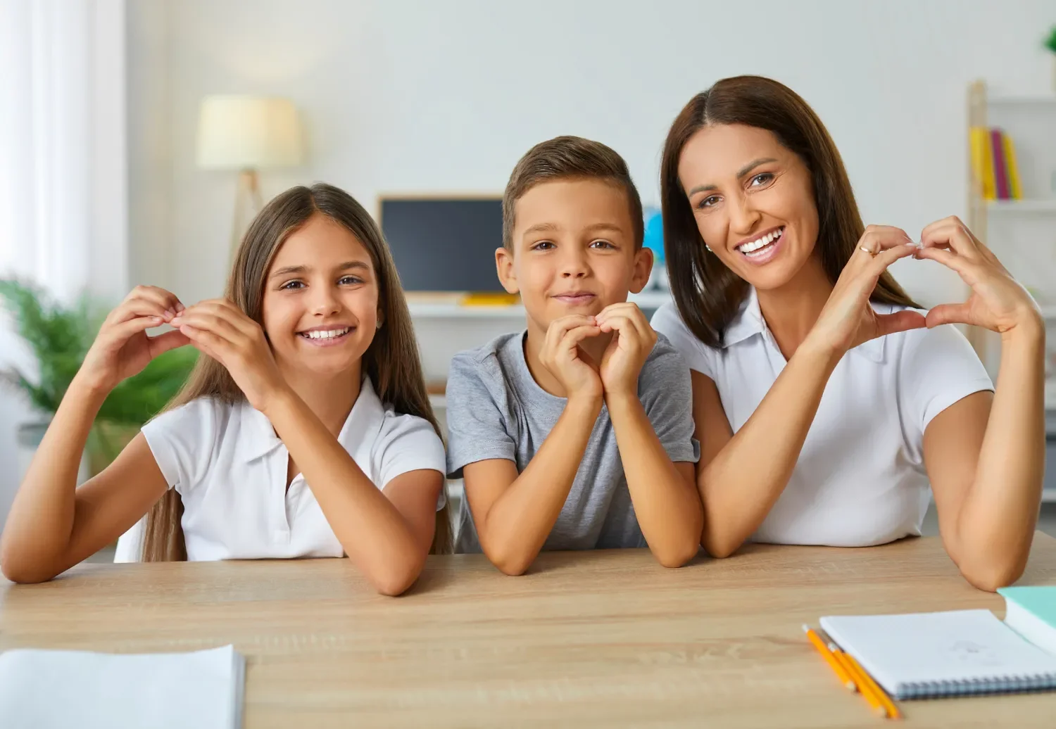 mom son daughter making heart hands and smiling