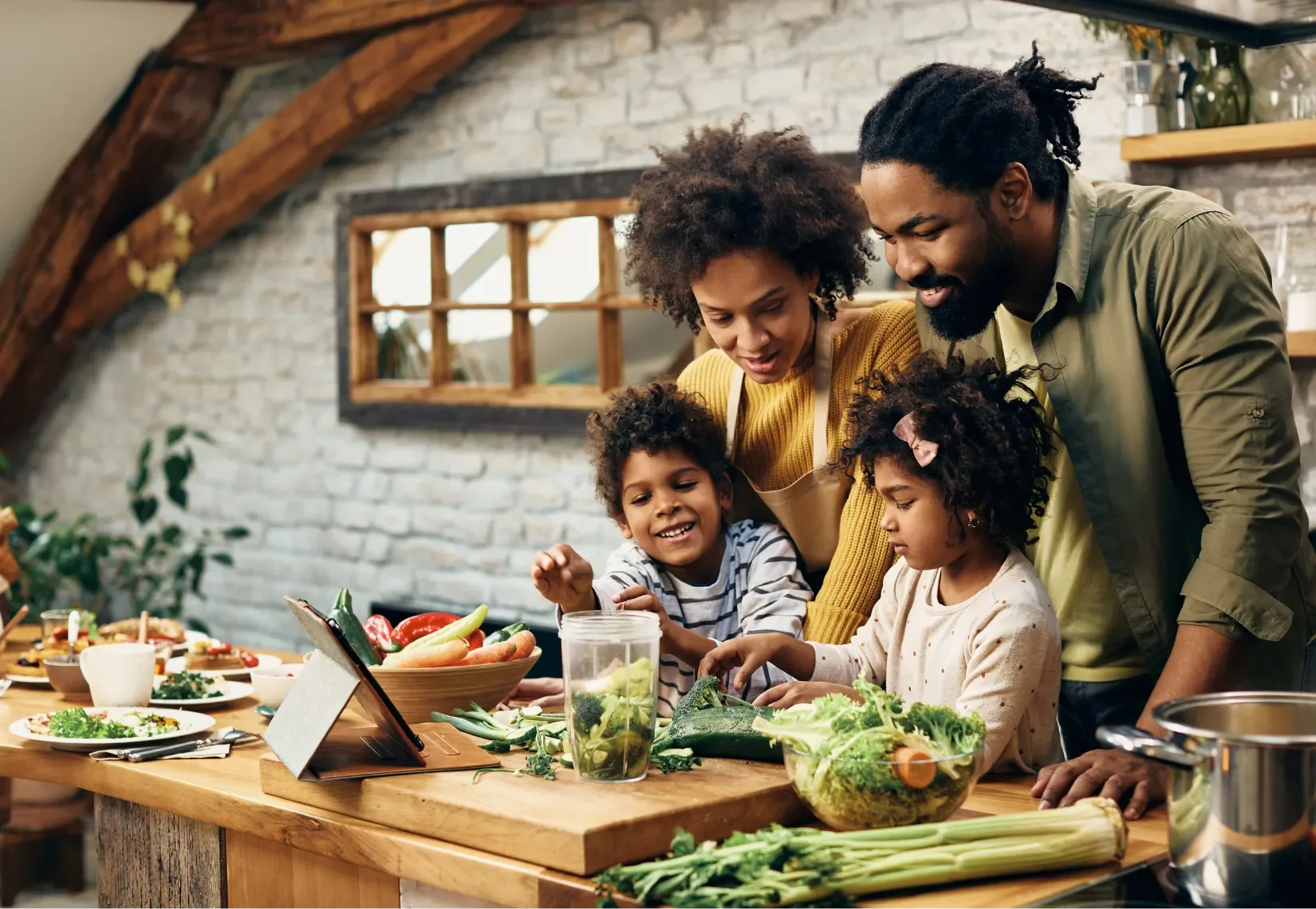 a family of four in a kitchen making a meal together