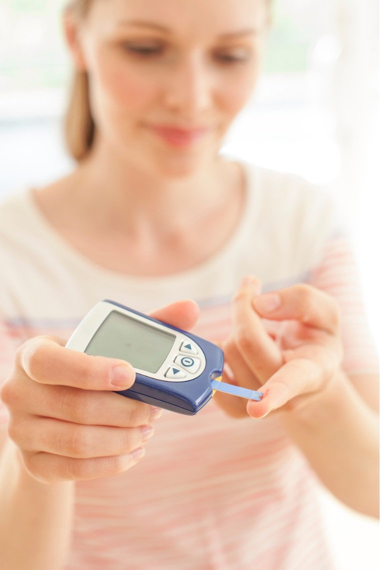 woman using blood glucose monitor