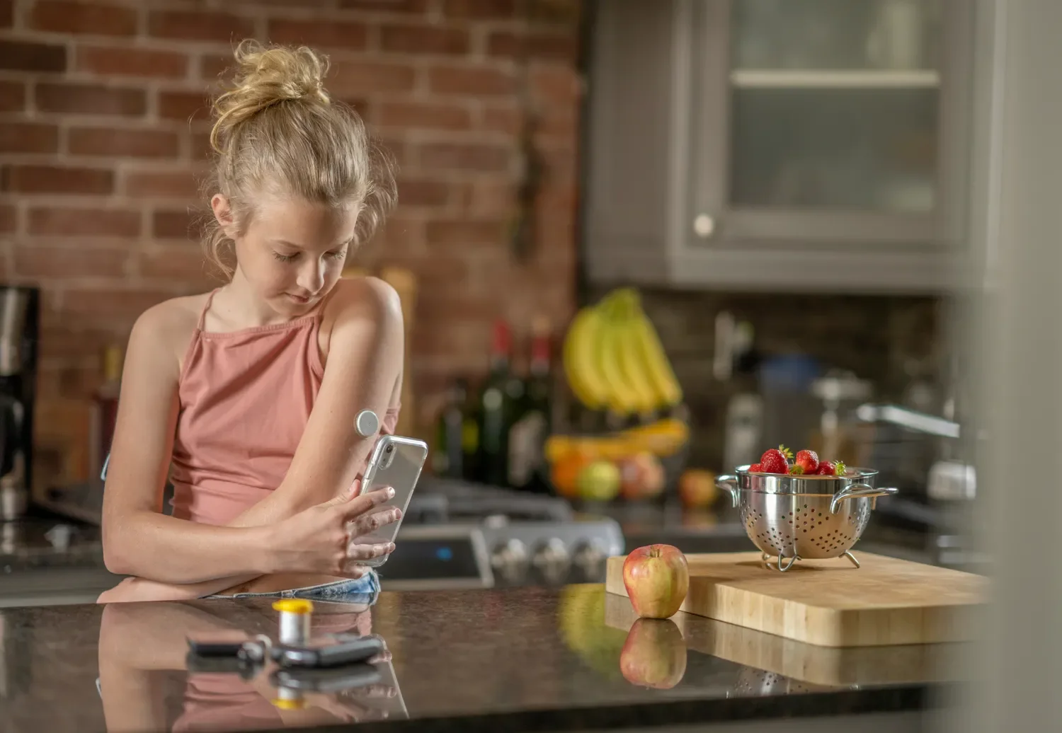 young girl monitoring her blood glucose on smart phone