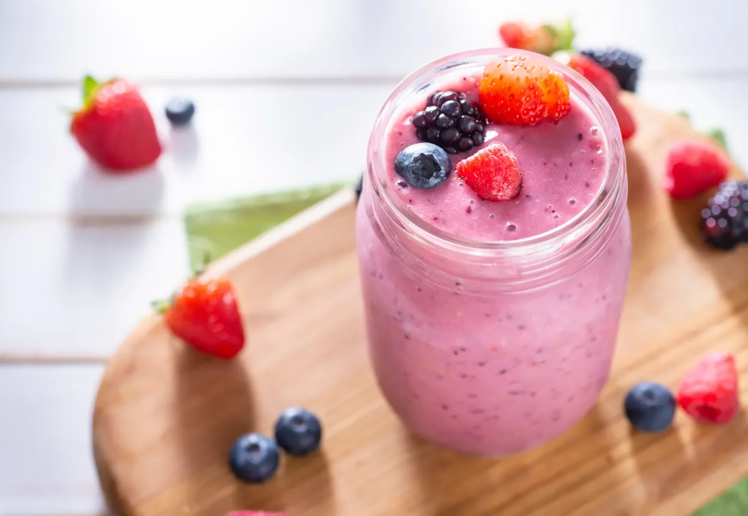 smoothy in a mason jar with strawberry raspberry blueberry blackberry