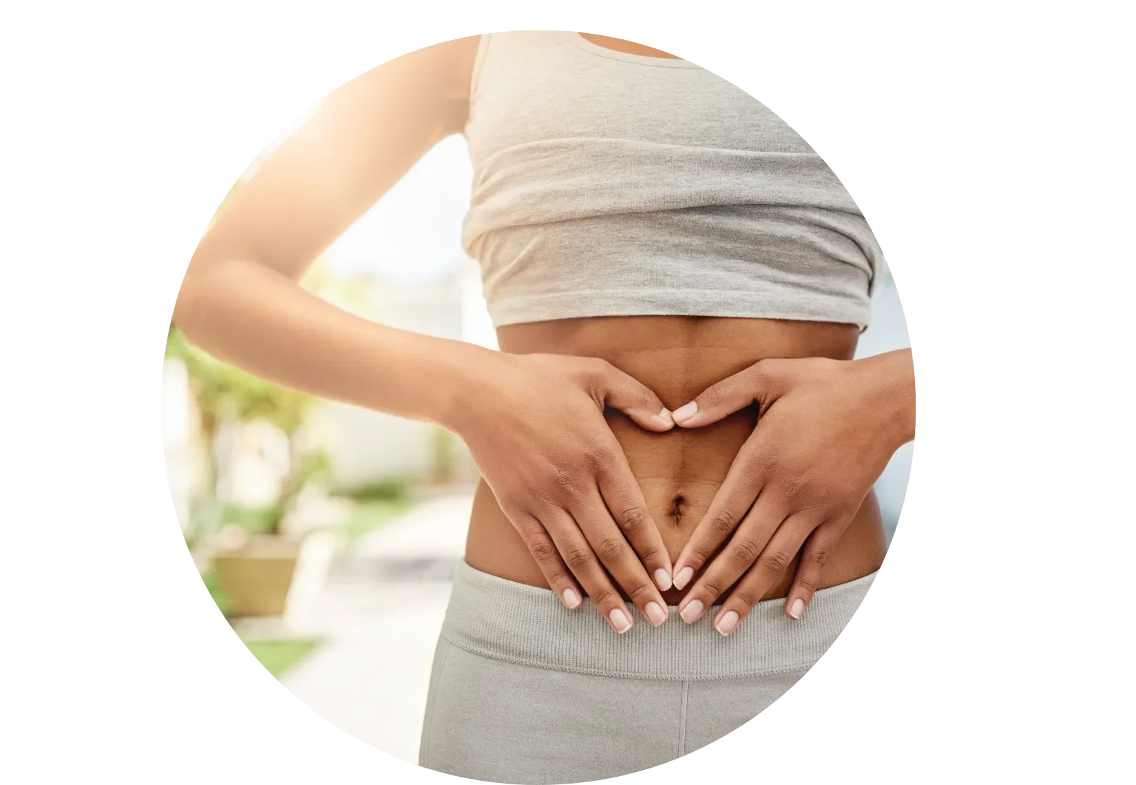 woman making heart shape with hands on stomach