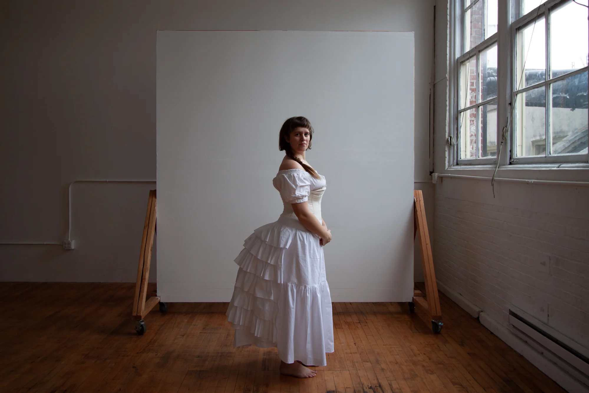 Myself as Kirsten, wearing a chemise, corset, and bustle, modeled after the fashion trends of the early 1870s.