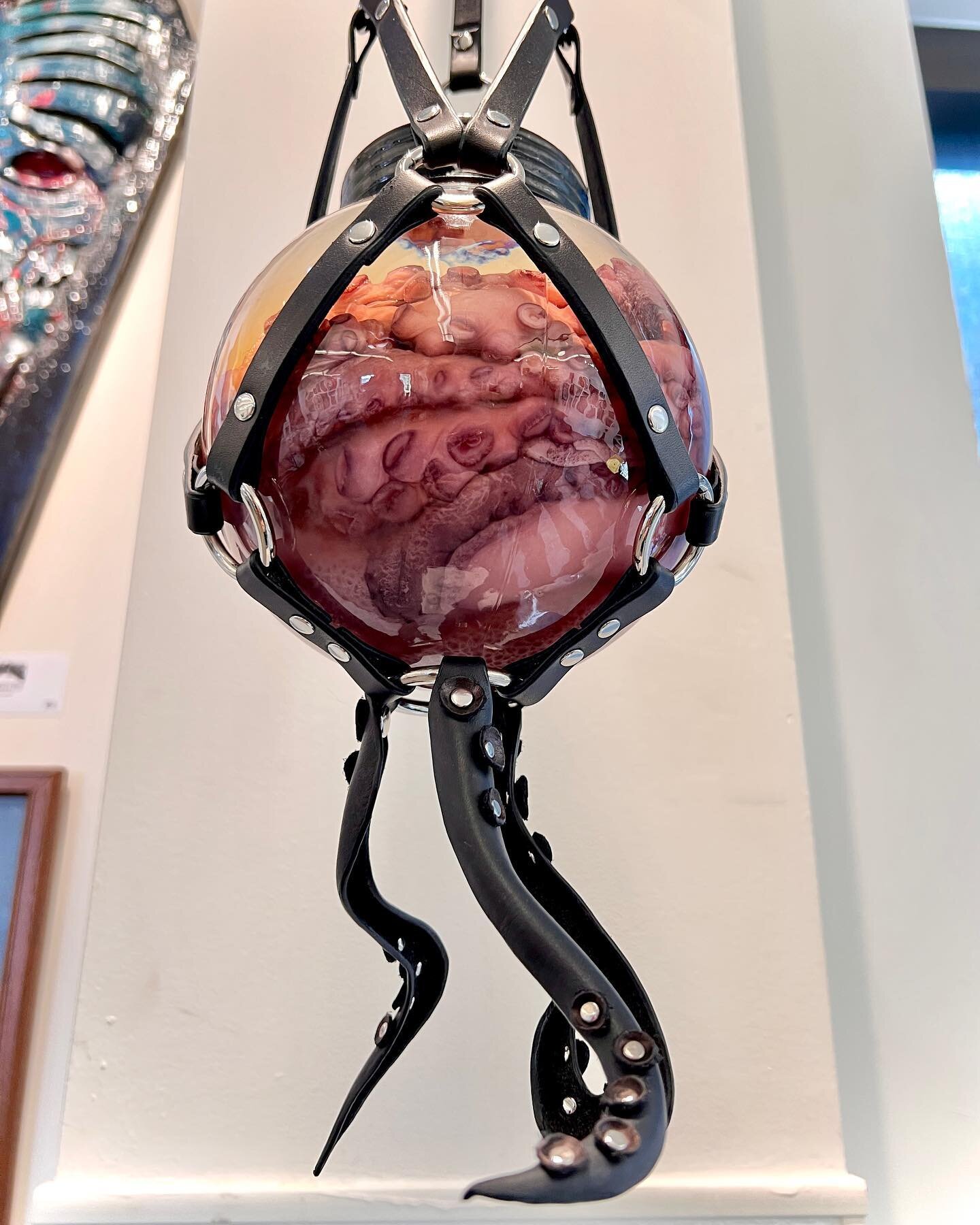 Harnessed Octopus. 
Wet preserved octopus in a glass globe hanging in a leather harness with wet molded leather tentacles hanging down. 🐙
On display at @otherworldlyartscollective Gods &amp; Monsters show at @jacflats 
Gallery hours Saturdays &amp; 