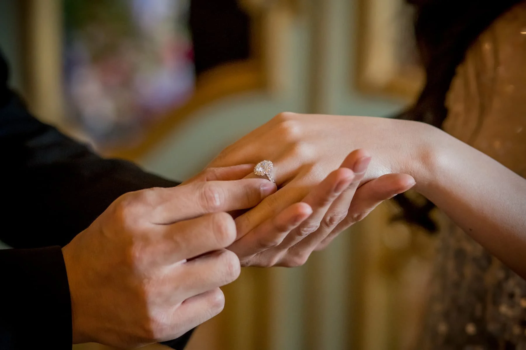 A close-up shot of a partner sliding a sparkling diamond engagement ring onto a finger during a luxury proposal in Tuscany.