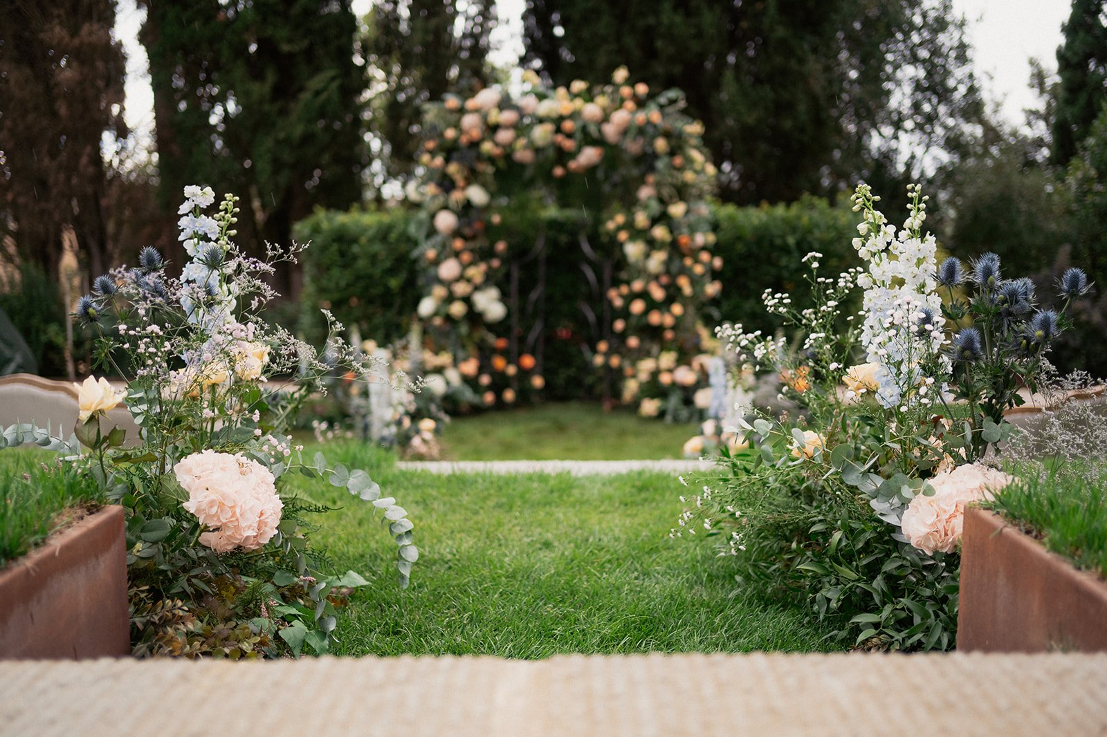 John_Pete_wedding ceremony arch with Tuscan cypresses in the background.jpg