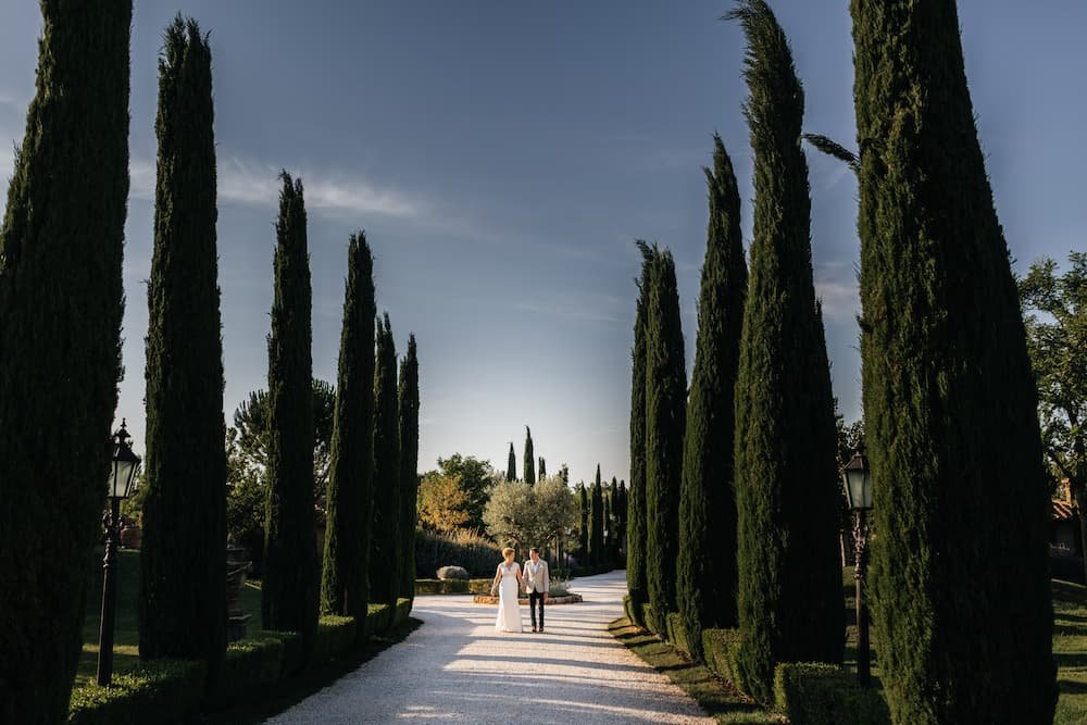 Bride and groom at the entrance of Borgo Santo Pietro in Tuscany.jpeg