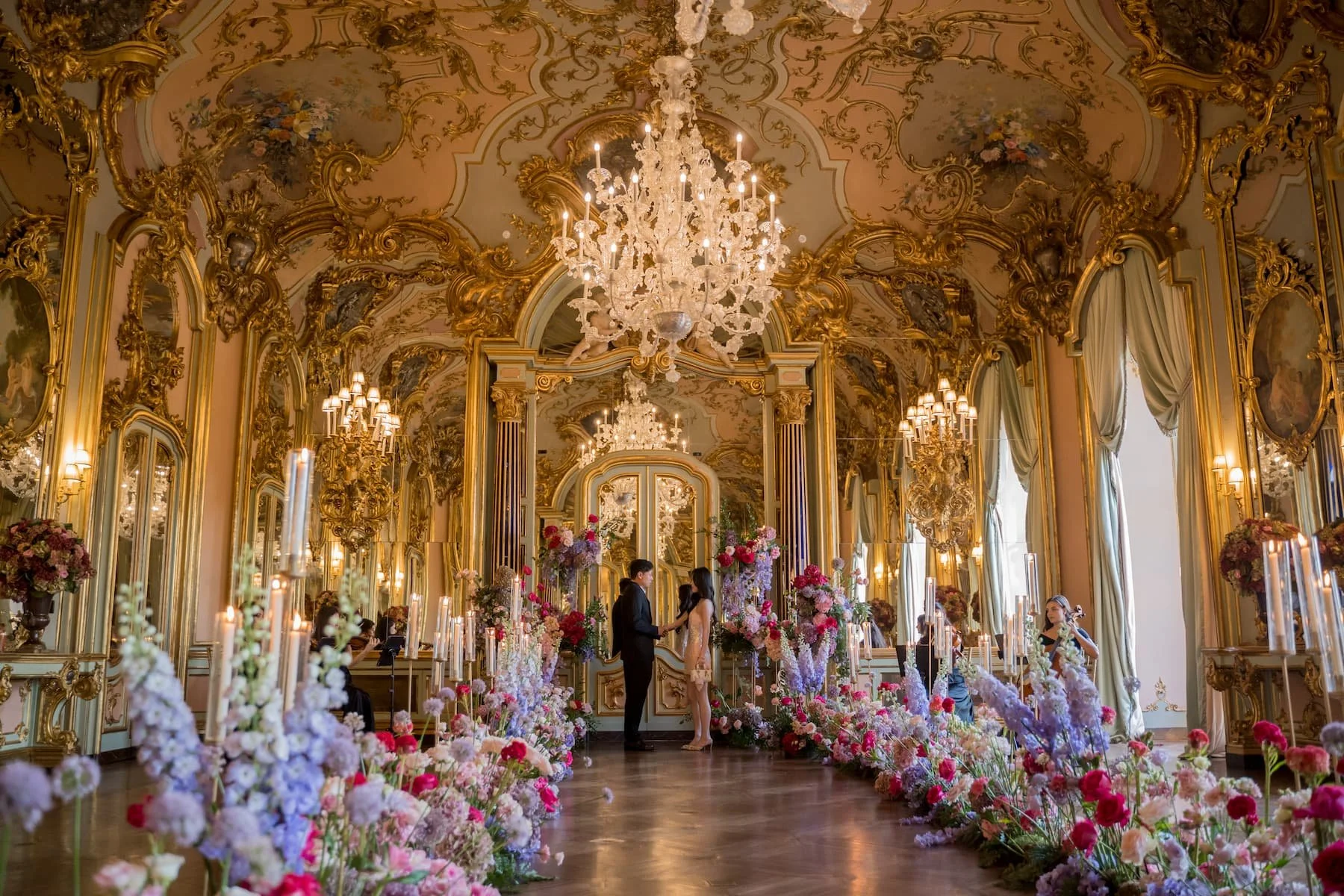 A breathtaking luxury marriage proposal setup inside a grand historic Tuscan palace featuring ornate golden architecture, crystal chandeliers, and a lavish aisle of floral arrangements.