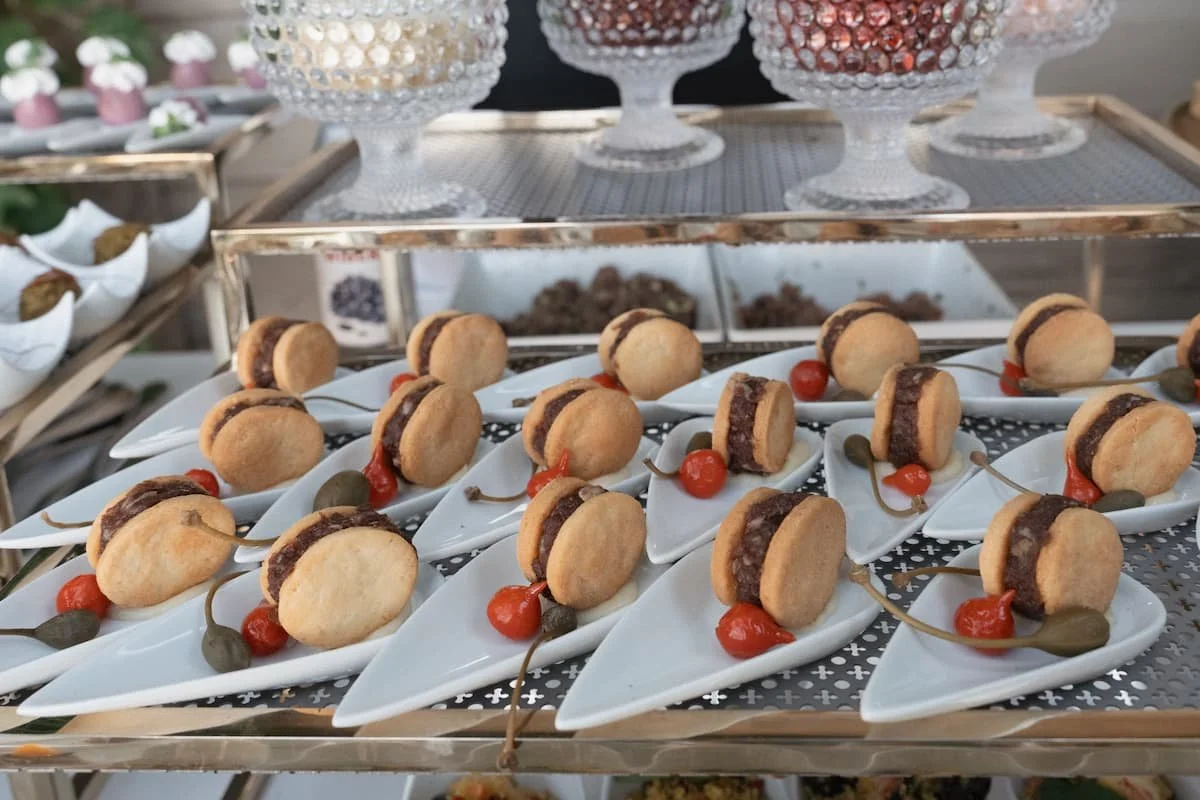 Gourmet cocktail hour finger food and savory appetizers on individual display spoons for a luxury wedding catering setup in Tuscany.