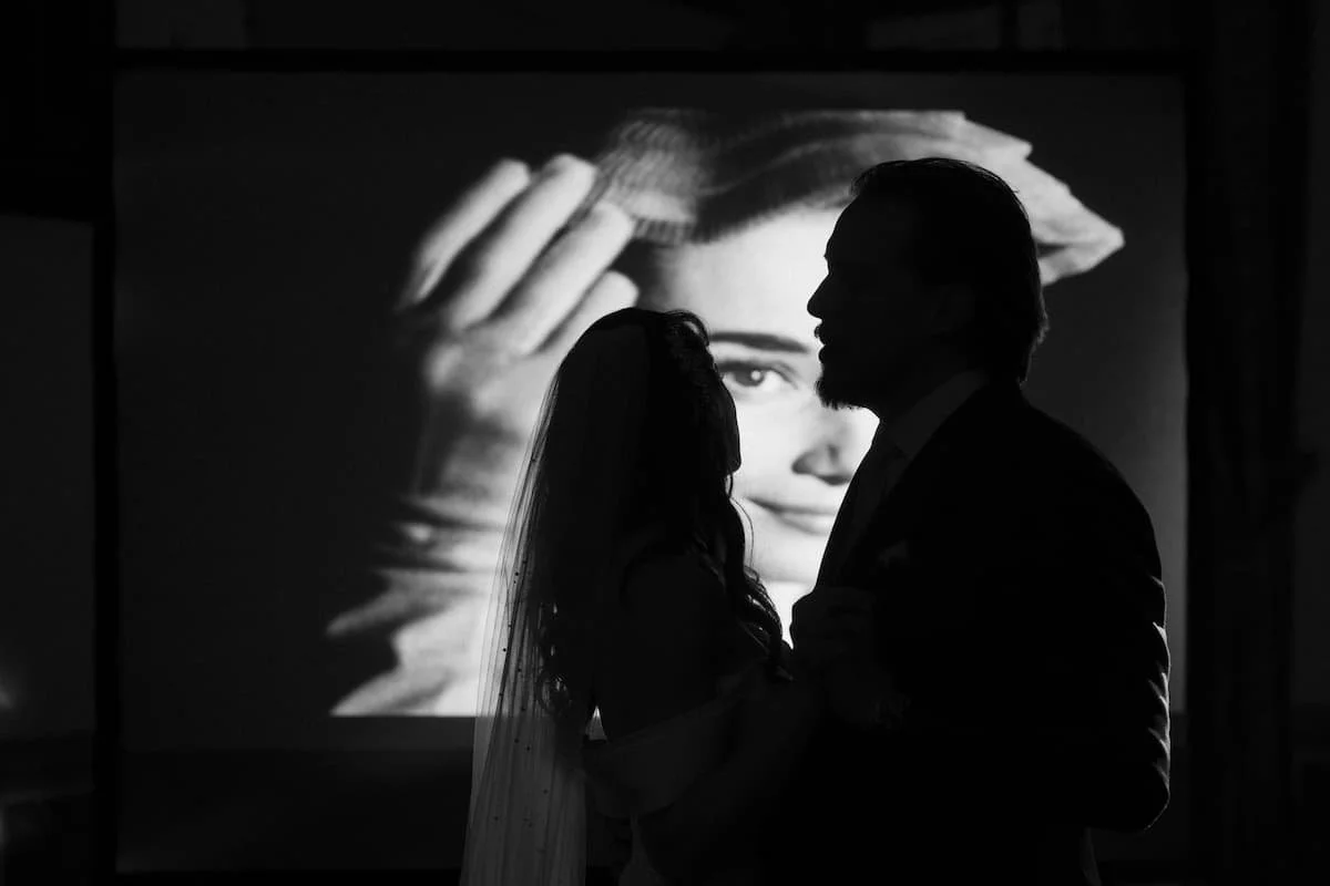 Silhouette of bride and groom first dance projected against Roman Holiday movie screen at Villa Corsini.