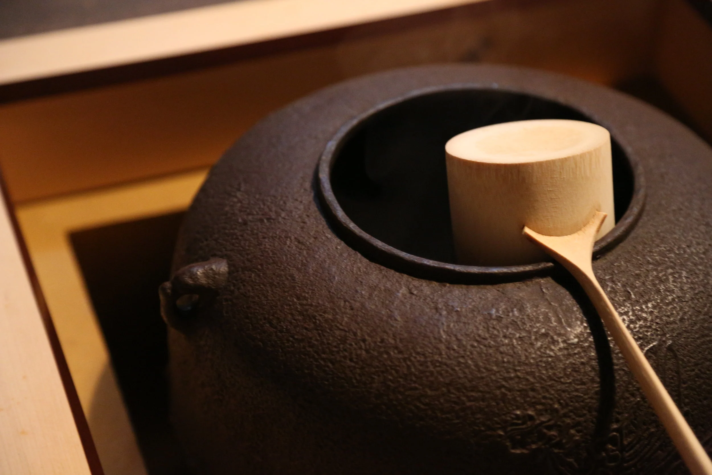 A larger iron pot (placed in the ro opening that contains an open flame) used to boil water for tea ceremony. ©TOKI