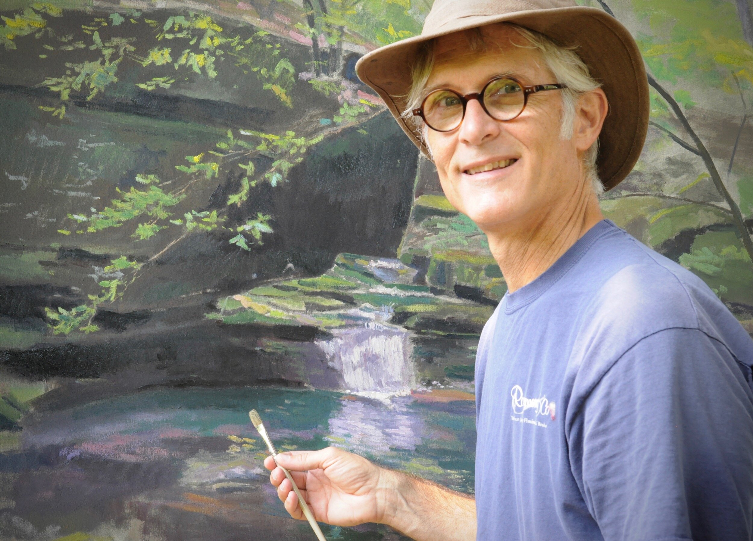 Matthew Lee in front of painting of falls in Arkansas