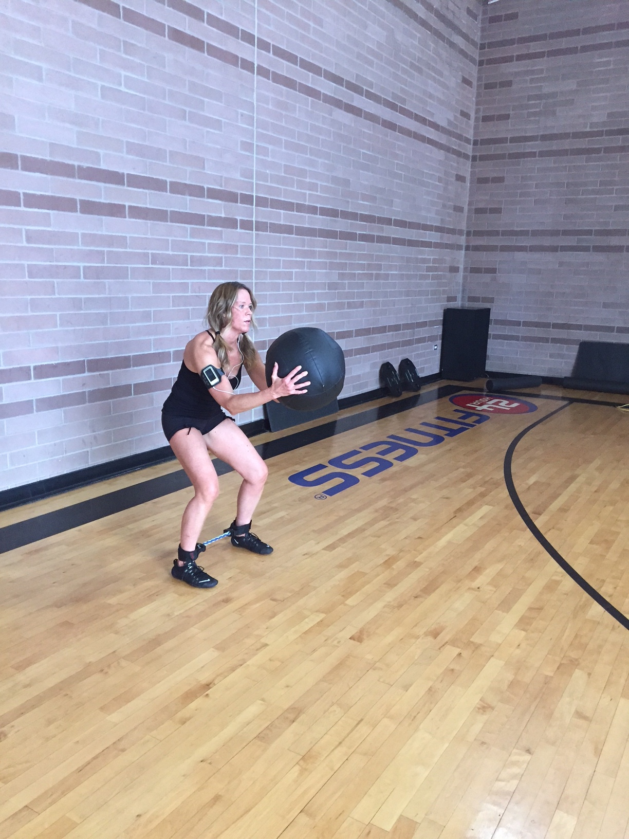 Place bands around ankles and with weighted plate, ball or dumbbell squat jump across gym