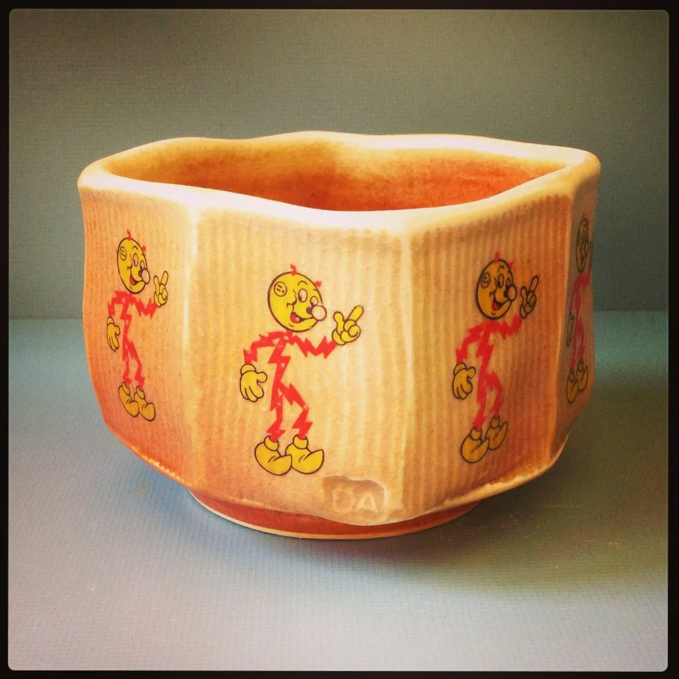 Dan Anderson, Reddi Kilowatt bowl, 2014, Porcelain, thrown, faceted and altered square, Wood fired and decal fired 4” x 4 1/2” x 4 1/2”