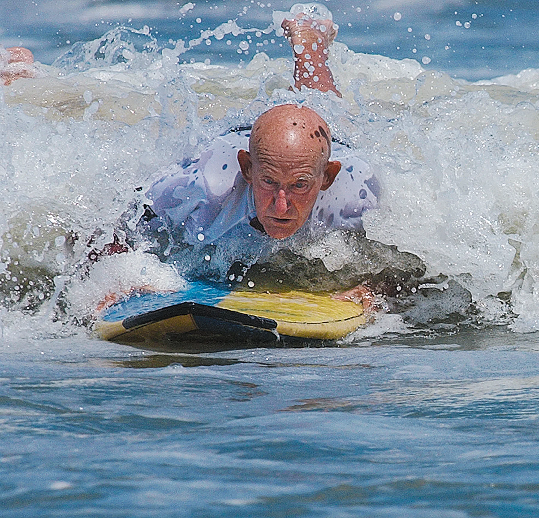  Howie Lyon, 82, of St. Augustine skims over a crest while surfing against John McCranels, 67, during the Grand Legends final at the Eastern Surfing Association's Southeastern Regional on Saturday, April 10, 2005. He never made it on his feet, but Ly