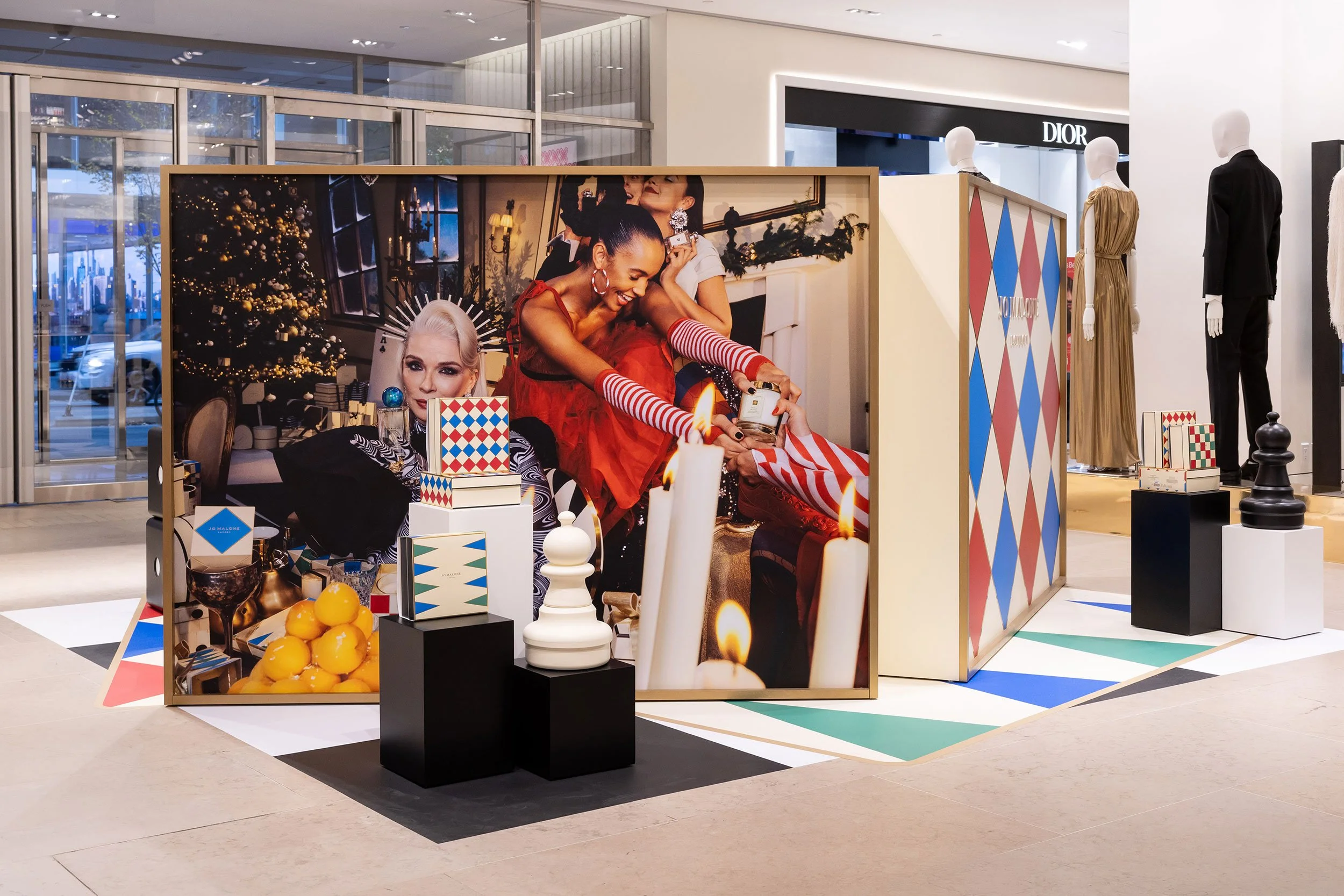 McWood's custom Jo Malone London board game display at Holt Renfrew Centre in Toronto featuring oversized wooden dice, illuminated game cabinets, custom acrylic lettering, and brass Scrabble® tile holders.