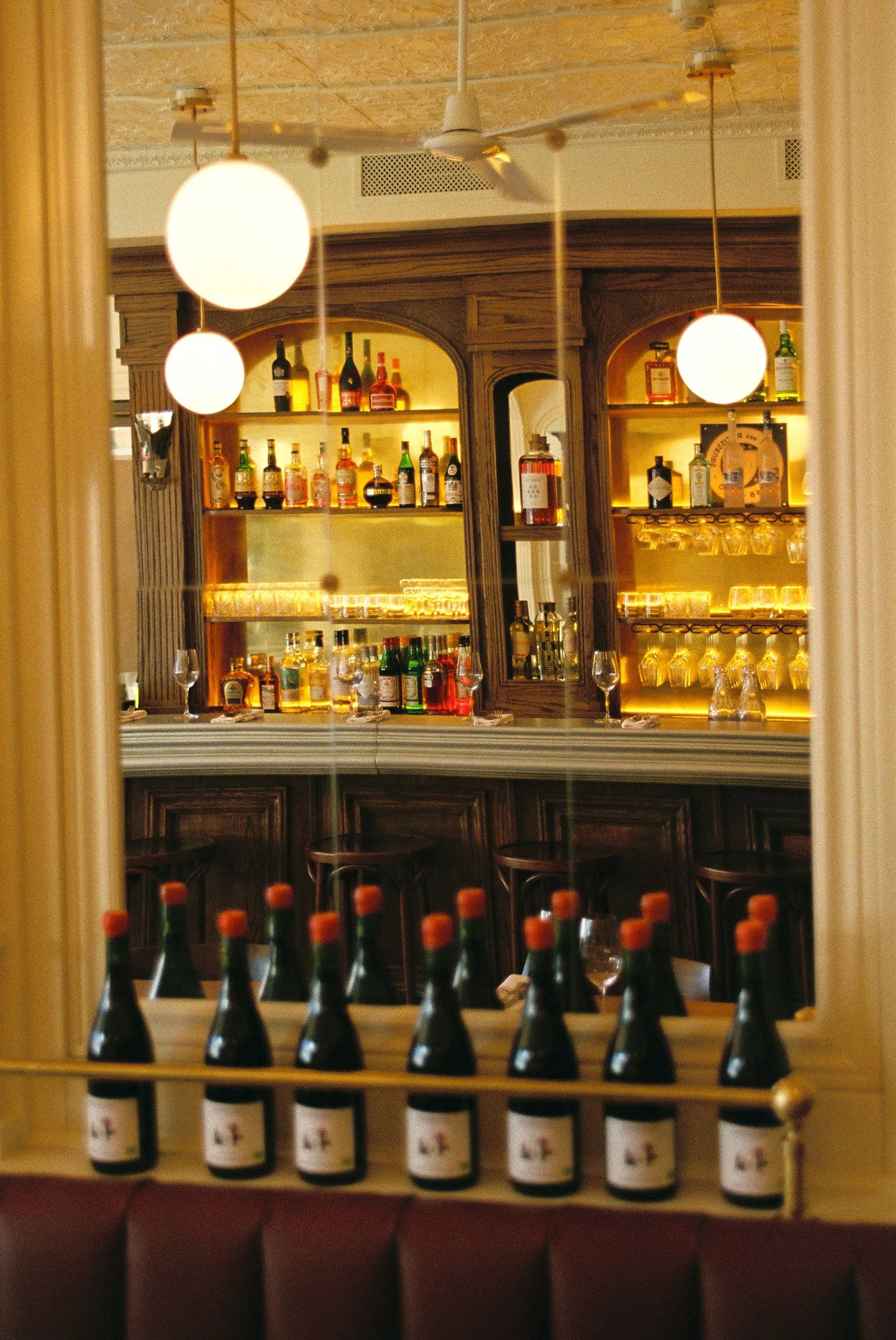Custom bar and bar back at Brasserie Côte with bottle display, designed and fabricated by McWood.