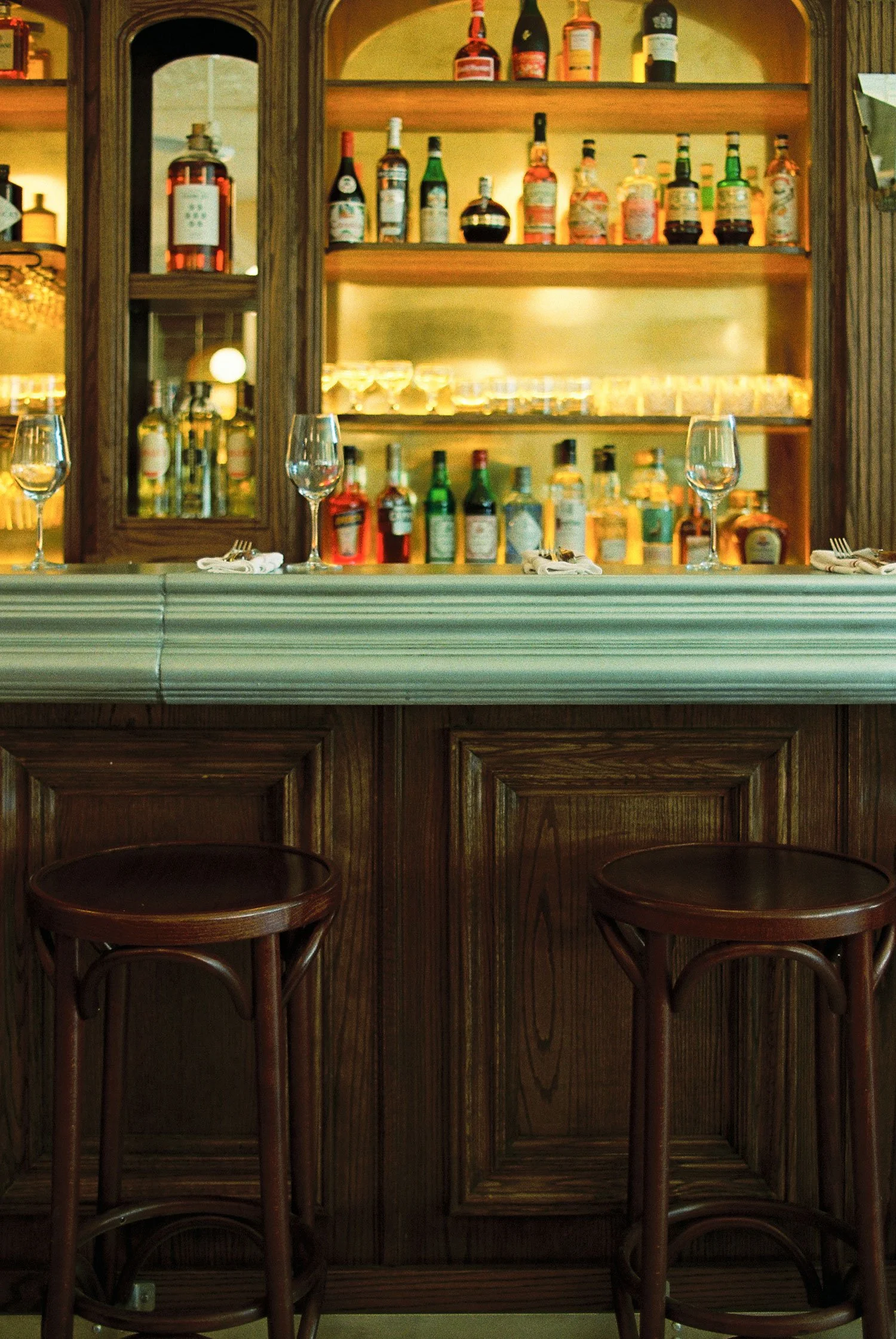 Custom bar and bar back at Brasserie Côte with bottle display, designed and fabricated by McWood.