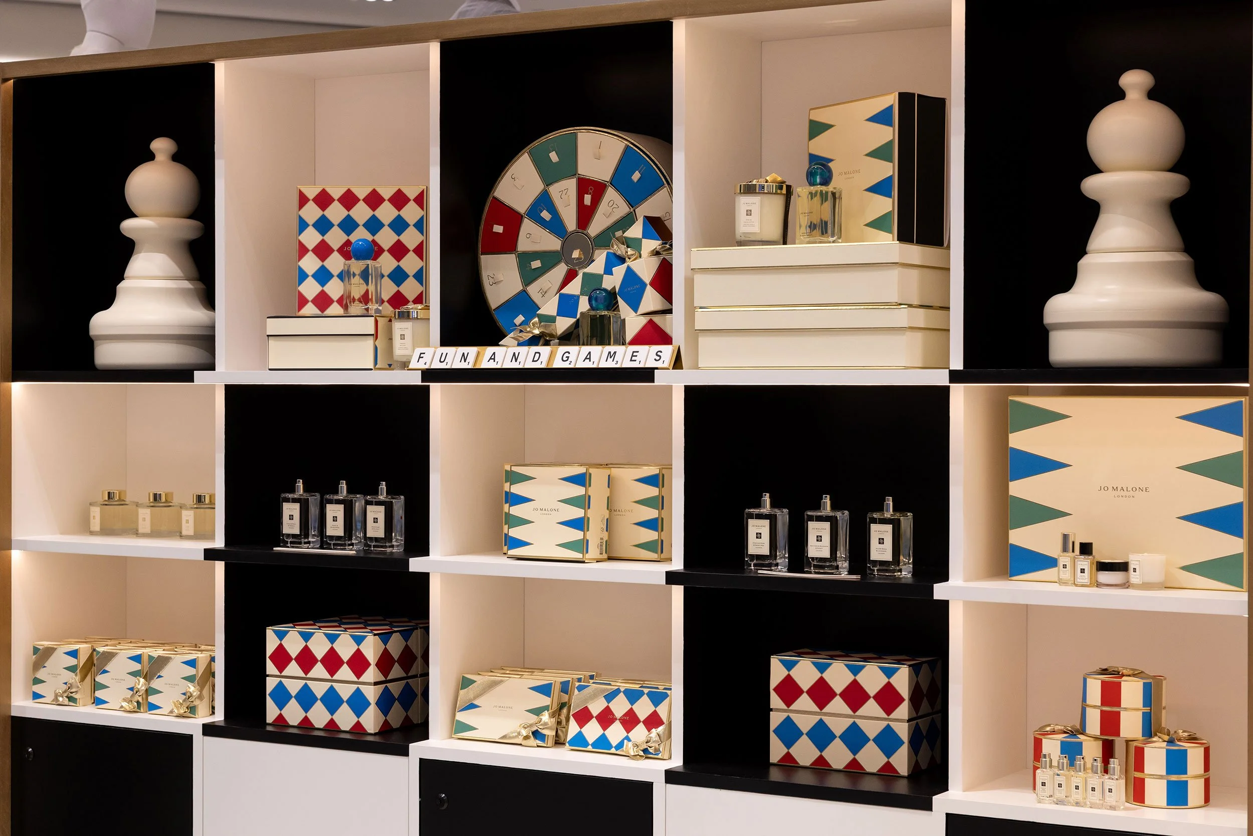 Custom illuminated display shelves fabricated by McWood for the Jo Malone London board game installation at Holt Renfrew Centre in Toronto, showcasing precision cabinetry, brass details, and LED lighting.