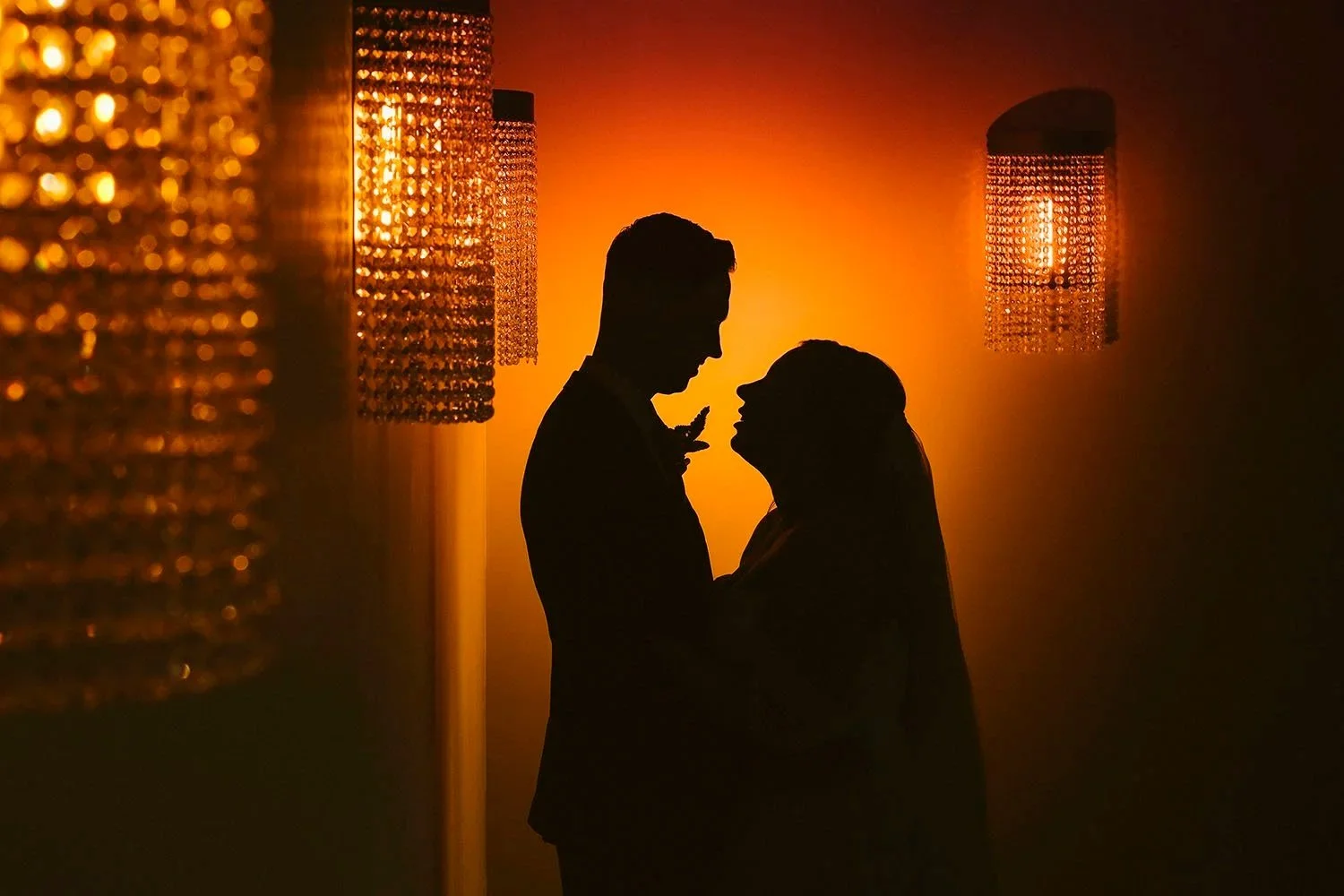 groom-and-bride-silhouette-glowing-orange-wall-crystal-lights-the-willows-at-the-woodman.jpg