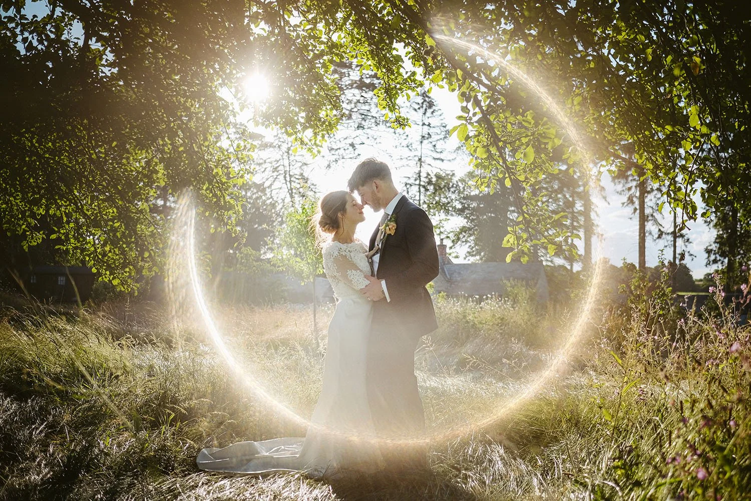 Newlywed bride and groom embracing outdoors in a sunlit garden