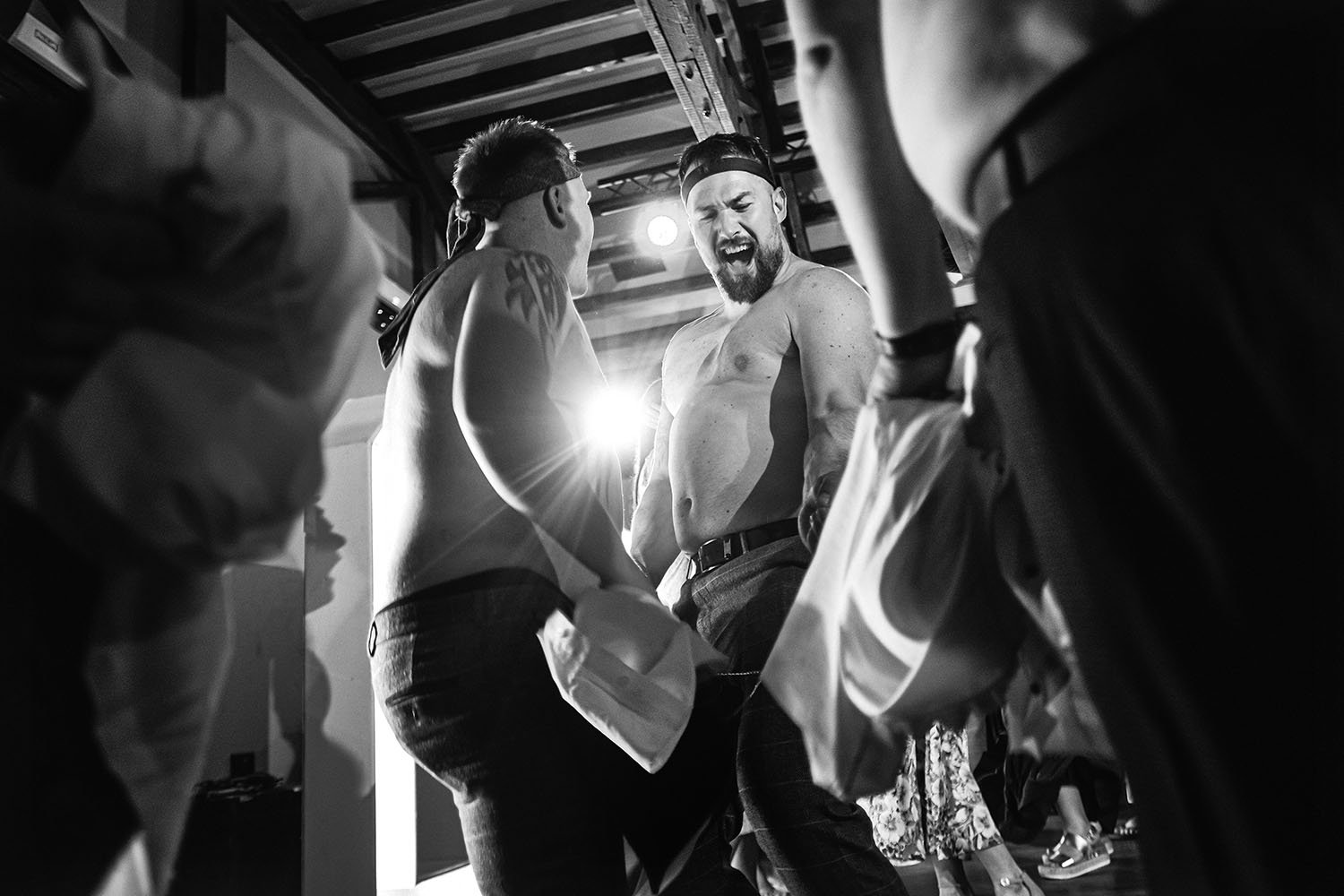 South Causey Inn wedding: two men dancing shirtless in a beamed barn at the party, in black and white.