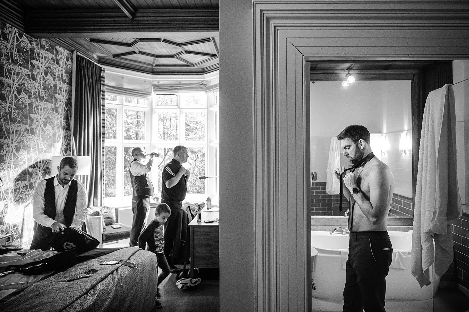 Jesmond Dene House wedding: groomsmen getting ready in a hotel suite in black and white
