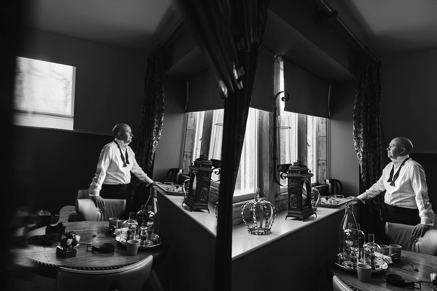 Ellingham Hall wedding: two men waiting at window seats in a dark room, in black and white.