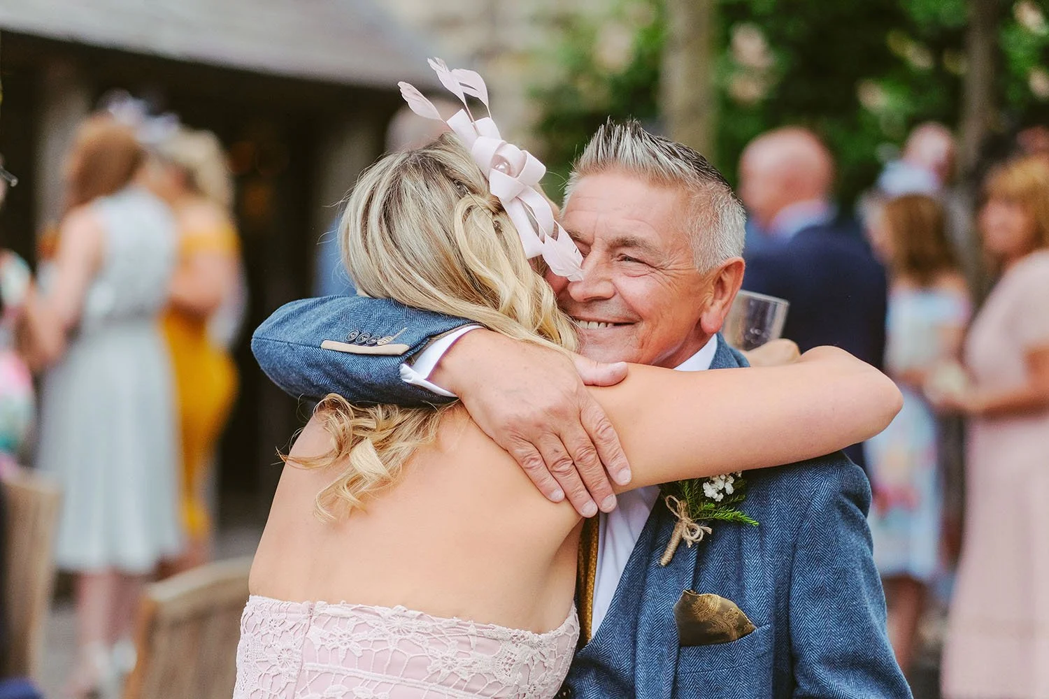 Healey Barn wedding: bride hugging her father in a garden at the wedding reception