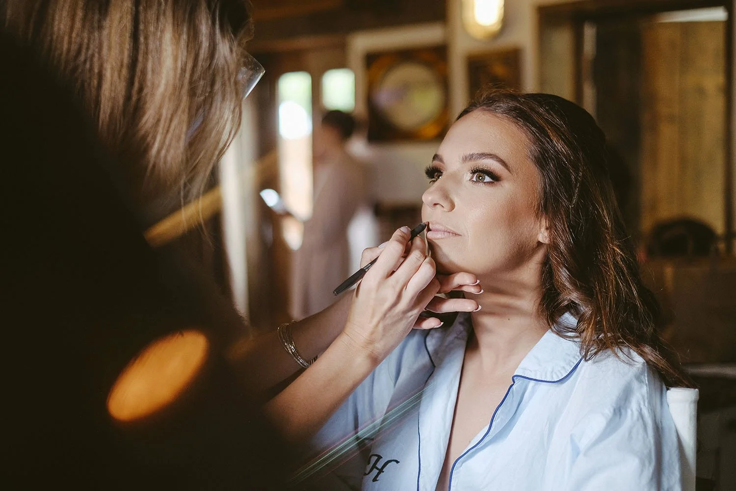 South Causey Inn wedding: bride having her lipstick applied by a makeup artist while getting ready.