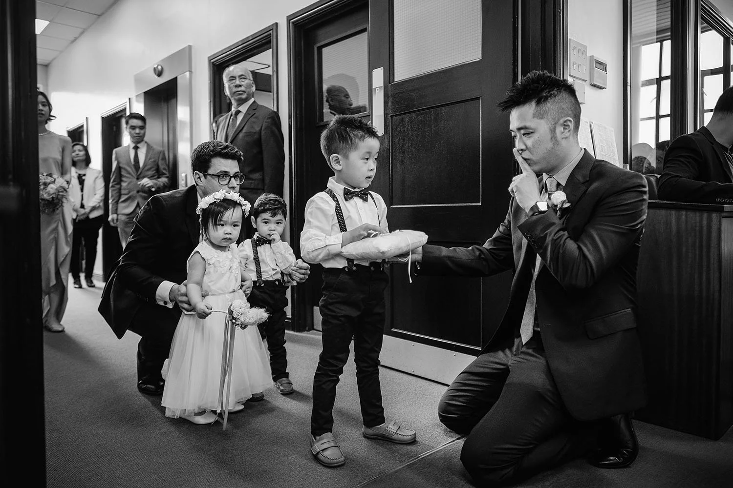 True Jesus Church wedding: ring bearer, flower girls and groomsmen lining up before the ceremony, black and white