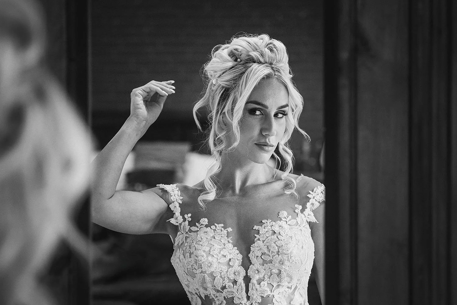 South Causey Inn wedding: bride in a lace gown adjusting her hair and looking to the camera from a dark doorway