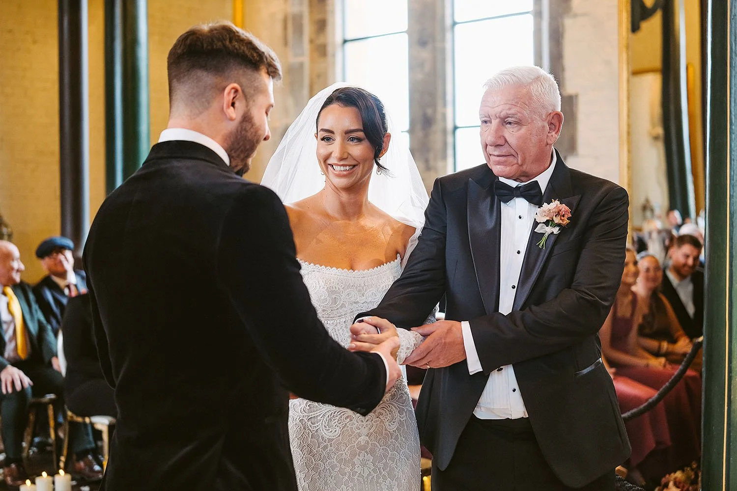Dalton Pump House wedding: bride smiling in her veil as her father in a bow tie takes the groom's hand at the start
