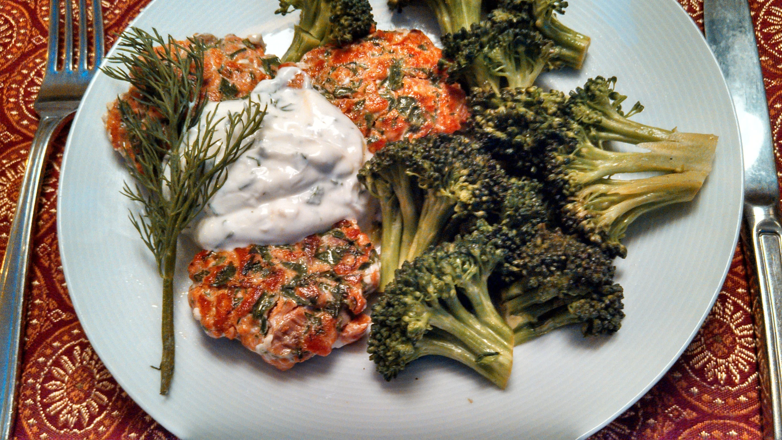 Home made salmon burgers with yogurt sauce and broccoli