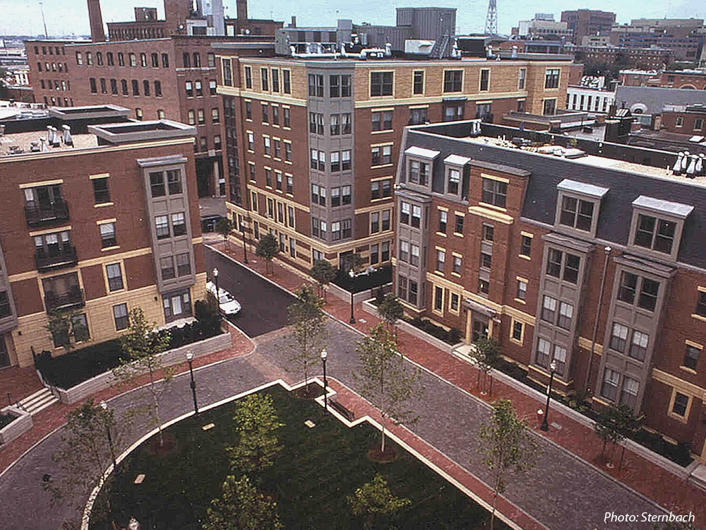 This 184-unit housing development was built on approximately two acres of vacant land. A goal for the project was to provide the City with significant open space. To achieve this, a 277 space, below grade parking garage was created with a park on its surface. Thus, the park at grade level is in reality a rooftop garden. This green space is a contemporary interpretation of the traditional South End Square. 
