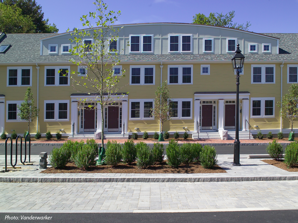 Twenty units of affordable housing were constructed on the former DPW site in downtown Newburyport. The townhouses are organized around a circular driveway, which forms a cul-de-sac. The center is landscaped with shade trees, shrubs, decorative streetlights and bike racks. Each unit has granite entry steps and a rear patio and garden. Brick sidewalks, granite curbs, and cobblestone parking areas help integrate the new development with its historic surroundings. 