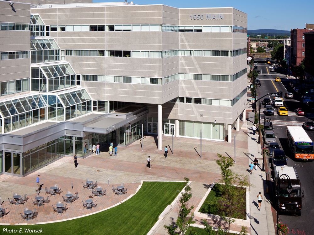 For the conversion of this downtown former courthouse to offices with ground floor retail, it was imperative to have an inviting, dynamic plaza that improved curb appeal and circulation. The design was constrained by an existing underground garage below the plaza. Undulating expanses of raised lawn, kept low for visibility, create a green streetscape, define circulation to the new retail spaces, and provide room for a generous area for café tables and chairs. New lighting and wide paver bands accentuate the path to the main door. 