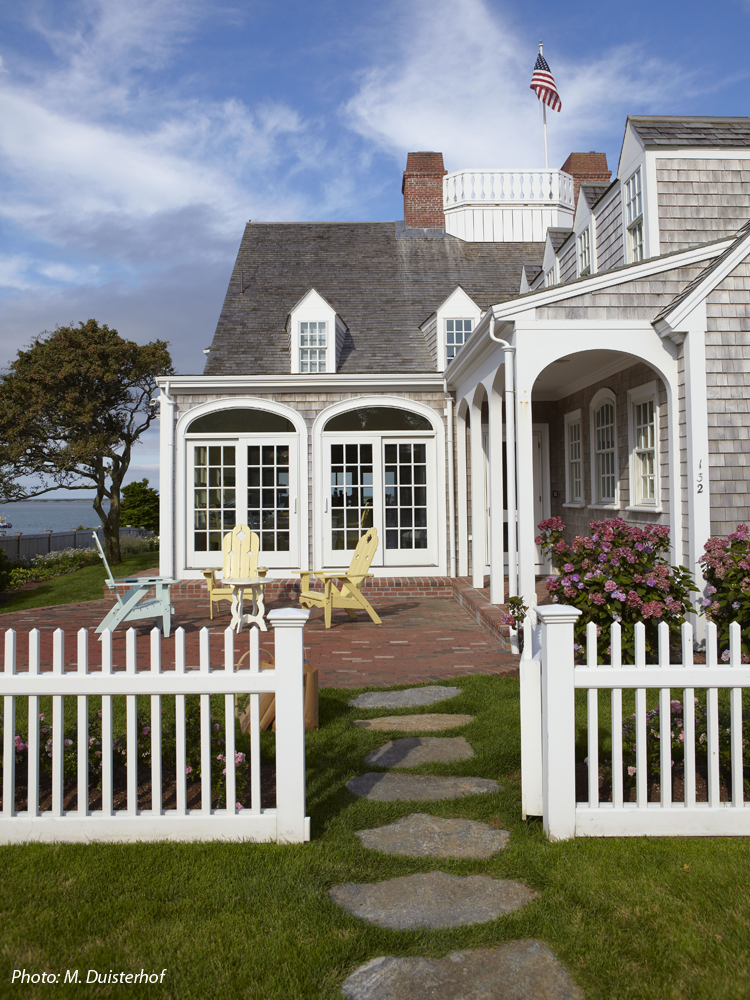 CBA created a beautiful landscape setting for this iconic home on Shore Road in Chatham which was featured in Country Living Magazine. The driveway was reconfigured to make a more inviting entrance that focuses on the house and the sea beyond. A field stone wall was designed to give the house and the immediate grounds a base on which to rest. A picket fence lined with roses defines the foreground of the house. Bluestone stepping stones welcome the guests through the arbor to the main door at the side of the house. Colorful, easy care perennials surround the house and an elevated patio at the rear of the house offers spectacular views. 