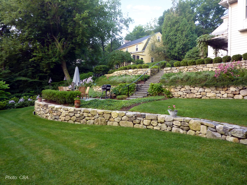  As detailed in the 2010 article "Hillside Havens" in Backyard Solutions Magazine, CBA turned what had been a neglected, overgrown hillside into unique, usable spaces. Graceful, curving stone walls tie three terraced spaces together, creating a unifi