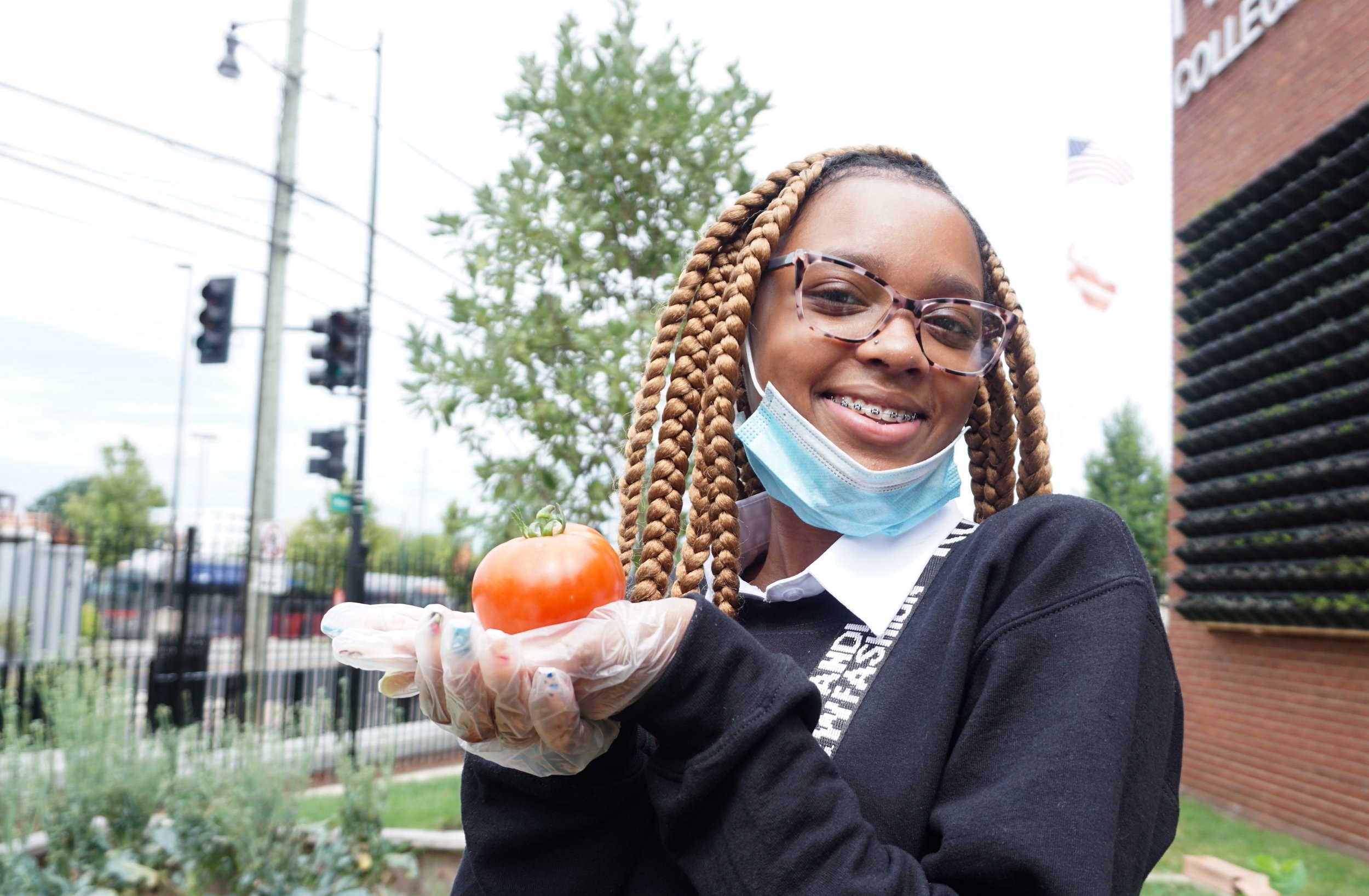 FNN reporter, Quinae’ Morton shows off a tomato from Collegiate’s urban garden. 