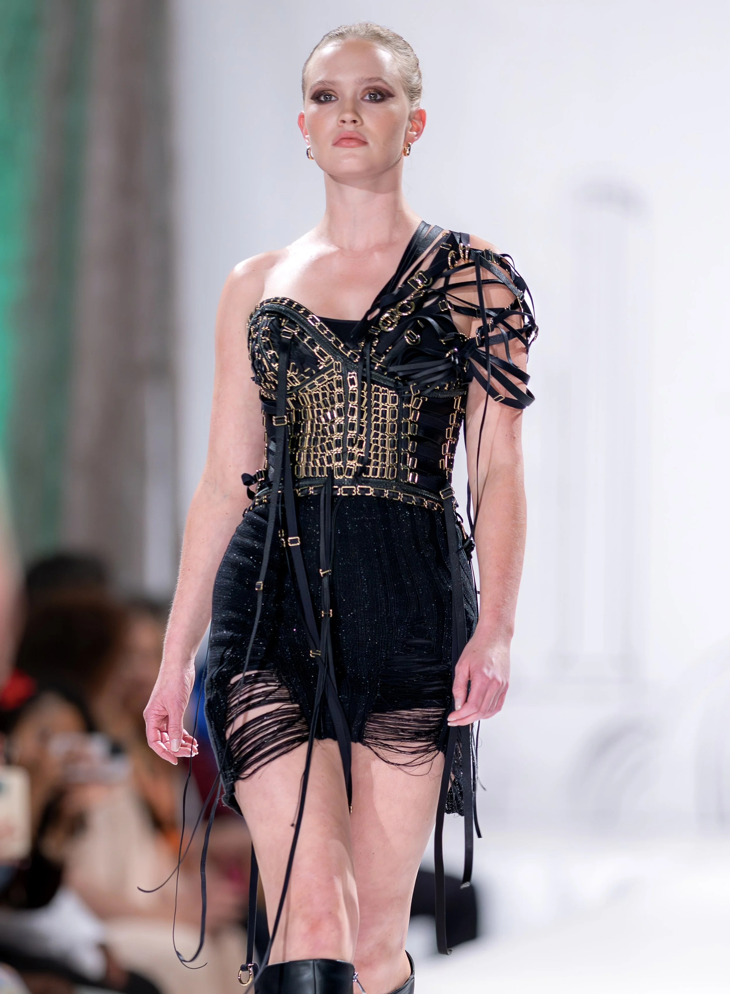 Handcrafted adjustable corset constructed entirely from reclaimed deadstock materials, featuring rubberized coated steel boning, laced satin bra elastic, gold-tone bra sliders, and a brass metal zipper. Black hand-knit deconstructed skirt in bamboo a